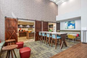 Hampton Inn & Suites Dallas-Allen في ألين: مطبخ وغرفة طعام مع طاولة وكراسي