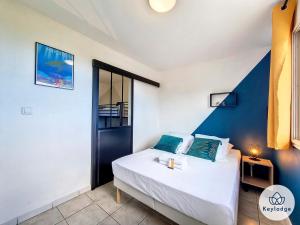 - une chambre avec un lit blanc et un mur bleu dans l'établissement Kaz Luma - Joliment décorée - Le Tampon, à Le Tampon