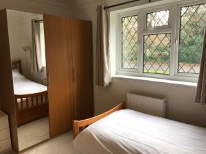 een slaapkamer met 2 bedden en een raam bij The Wendy House in Bournemouth