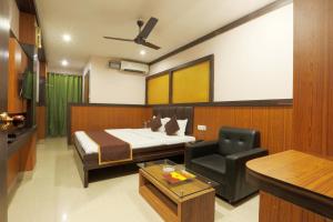 a bedroom with a bed and a chair and a desk at Hotel Dream City in Guwahati