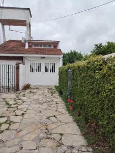 a house with a white garage and a stone driveway at Comodo Departamento en zona residencial in Mar del Plata