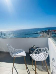 2 Stühle und ein Tisch auf dem Balkon in der Unterkunft La Dolce Vita Penthouse 2 Bedroom Apartment in Arona