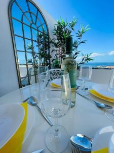ein Tisch mit Gläsern und eine Flasche Wein darauf in der Unterkunft La Dolce Vita Penthouse 2 Bedroom Apartment in Arona