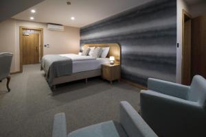 um quarto de hotel com uma cama e um sofá em Hotel Zlaty Klucik - Golden Key with Luxury SPA em Nitra