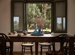 uma mesa com cadeiras e um vaso com flores em Phi Simple Living Quarters em Akrotiri