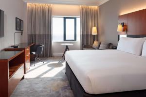 a hotel room with a large bed and a desk at Hilton Belfast in Belfast