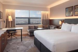 um quarto de hotel com uma cama grande e uma secretária em Hilton Belfast em Belfast