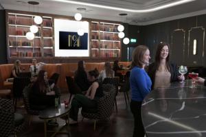 twee vrouwen aan een tafel in een restaurant bij Hilton Belfast in Belfast