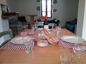 - une table avec une bouteille de vin et du pain dans l'établissement Paul's Barn in France, à Nantiat