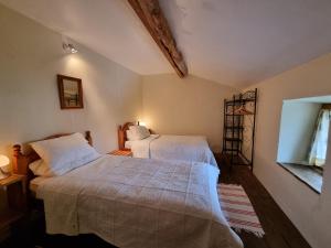 een slaapkamer met 2 bedden en een raam bij Paul's Barn in France in Nantiat