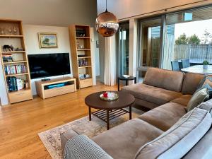 a living room with a couch and a tv at Bakki and Holt in Borgarnes