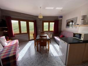 cocina y sala de estar con mesa y sofá en Tetras Pedrous, en Pas de la Casa