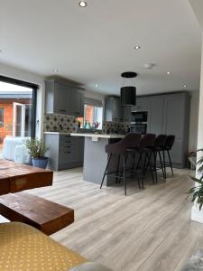 a kitchen and living room with a table and chairs at Modern Harrogate house sleeps 10, cinema room & hot tub in Harrogate