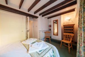1 dormitorio con 1 cama, escritorio y 2 sillas en Damson Cottage - Chocolate Box Cottage in Crook, near Bowness, en Crook
