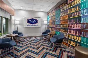 a lobby with chairs and a wall with a mural at Hampton Inn by Hilton Nashville Airport Century Place in Nashville +34 photos
