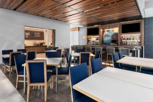 Hampton Inn by Hilton Nashville Airport Century Place في ناشفيل: غرفة طعام مع طاولات وكراسي وبار