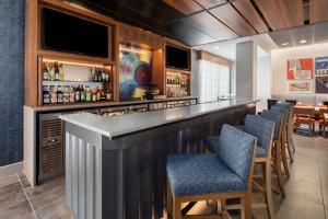 a bar in a restaurant with chairs and a television at Hampton Inn by Hilton Nashville Airport Century Place in Nashville