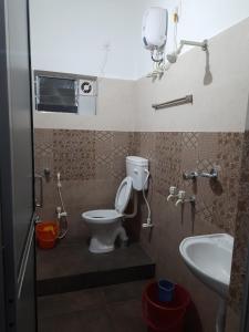 a bathroom with a toilet and a sink at Banpalashi Inn in Jhārgrām