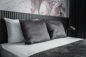 a bed with black and white pillows in a bedroom at Marrilux apartments Residence Hill in Kopaonik