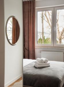 a bedroom with a mirror and towels on a bed at Ursynów Kłobucka Cosy Apartment in Warsaw