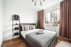Ursynów Kłobucka Cosy Apartment في وارسو: غرفة نوم بسرير كبير ونافذة