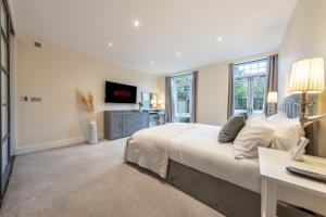 特威克納姆的住宿－Candler Mews - Twickenham，卧室配有一张白色大床和一张书桌