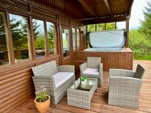 - une terrasse couverte avec des chaises en osier et une baignoire dans l'établissement Bakki and Holt, à Borgarnes