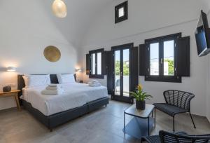 ein Schlafzimmer mit einem Bett und einem Stuhl und Fenstern in der Unterkunft Nostos Apartments Kamari in Kamari + 87 Fotos