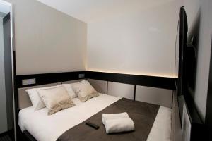 a small bed with two remote controls on it at Great St Helen Hotel in London