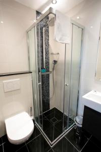 a bathroom with a shower and a toilet and a sink at Great St Helen Hotel in London