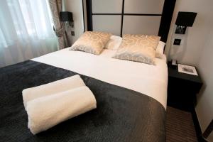 a bedroom with a large white bed with pillows at Great St Helen Hotel in London