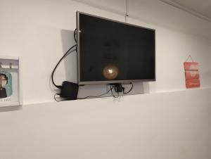 a flat screen tv sitting on a white wall at Comodo Departamento en zona residencial in Mar del Plata