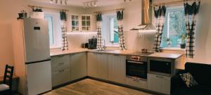 cocina con nevera blanca y algunas ventanas en Chalupa U Šťastných, en Jeseník 11 fotos más
