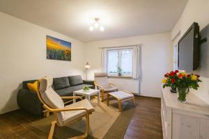 uma sala de estar com um sofá e duas cadeiras em Ferienwohnung zur Steinburg em Bad Schandau