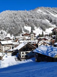 eine schneebedeckte Stadt mit einem Berg im Hintergrund in der Unterkunft Le Week-End 3 étoiles, plein centre ville in La Clusaz