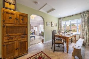 a dining room with a table and a large window at The Old Coach House C in Grimston