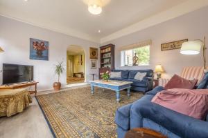 a living room with a blue couch and a table at The Old Coach House C in Grimston