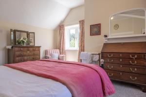 a bedroom with a bed and a dresser and a mirror at The Old Coach House C in Grimston