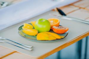 a plate of fruit with an apple and oranges at Makeri Residence - Musanze , Rwanda in Ruhengeri