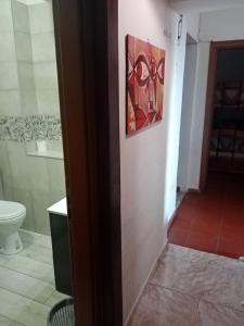 a bathroom with a toilet and a painting on the wall at Casa Siciliana Altarbiah in Trabia