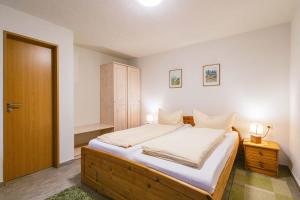 1 dormitorio con 1 cama con sábanas blancas y 2 lámparas en Ferienwohnung zur Steinburg, en Bad Schandau