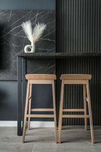 a desk with two stools and a vase with feathers at Marrilux apartments Residence Hill in Kopaonik