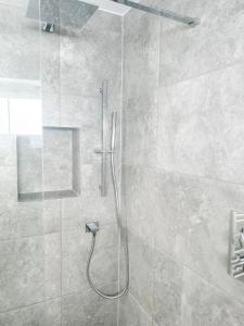 a bathroom with a shower with a glass door at The Studio @ Michael House in Horley