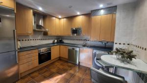 a kitchen with wooden cabinets and a table in it at Dúplex Terraza Golf 3 Dormitorios 2 Baños in Sabiñánigo