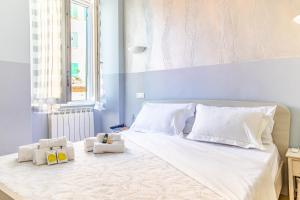 a bedroom with a white bed with two stuffed animals on it at Alla Marina Affittacamere in Riomaggiore