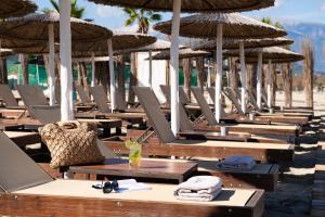 - une rangée de chaises et de parasols sur une plage dans l'établissement Olympic Star Beach Hotel, à Neoi Poroi