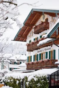 若特阿赫-埃根Spa & Resort Bachmair Weissach, LUXURY FAMILY RESORT的一座带阳台的雪地建筑