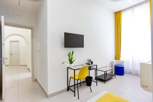 a dining room with a table and a yellow chair at V10 GUESTHOUSE - Vanvitelli 10 in Naples