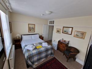 a small bedroom with a bed and a chair at The Black Horse Inn in Canterbury