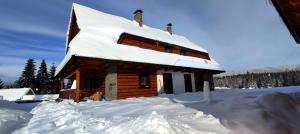 domek z bali i śniegiem na dachu w obiekcie Challet Tonka w Zuberzcu